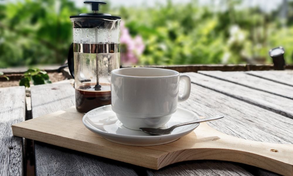 An image of a coffee cup and a French Press coffee.