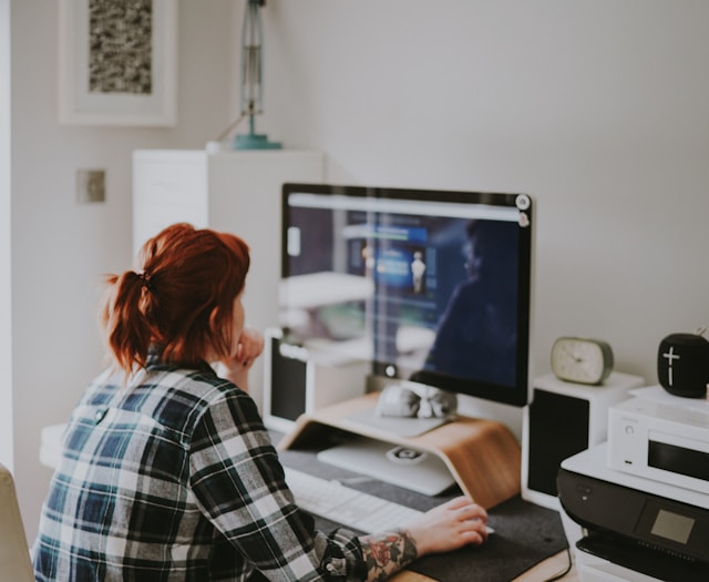 An image of a woman focusing on work at her computer.