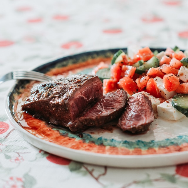 An image of a steak and tomato salad.