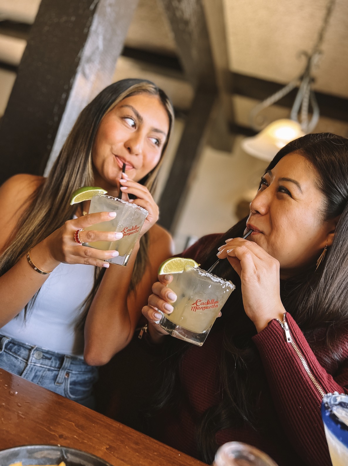 An image of two people drinking cocktails made with some of your favorite tequila brands.