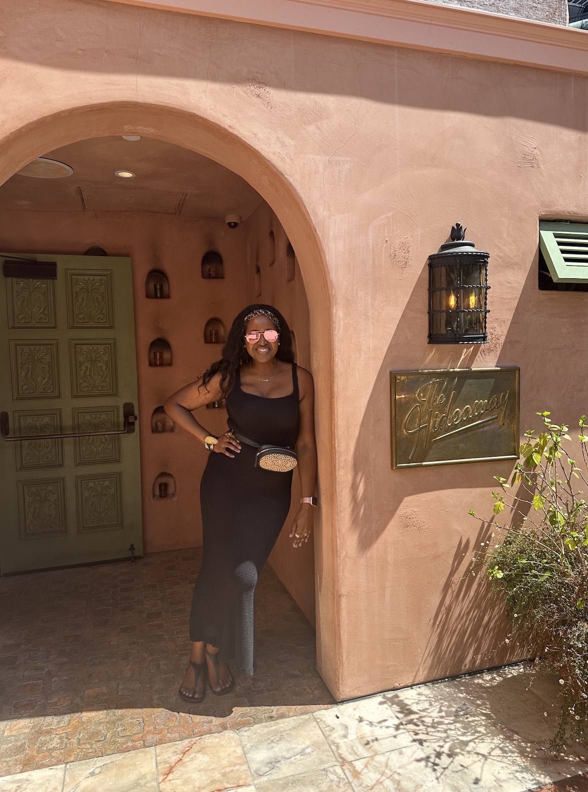 An image of lifestyle blogger Ariel leaning against the outdoor arch of The Hideaway Beverly Hills.