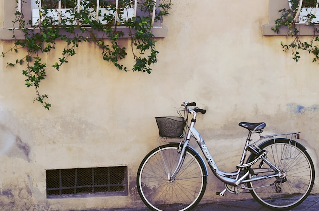 An image of a bike leaning against a Tuscany wall.