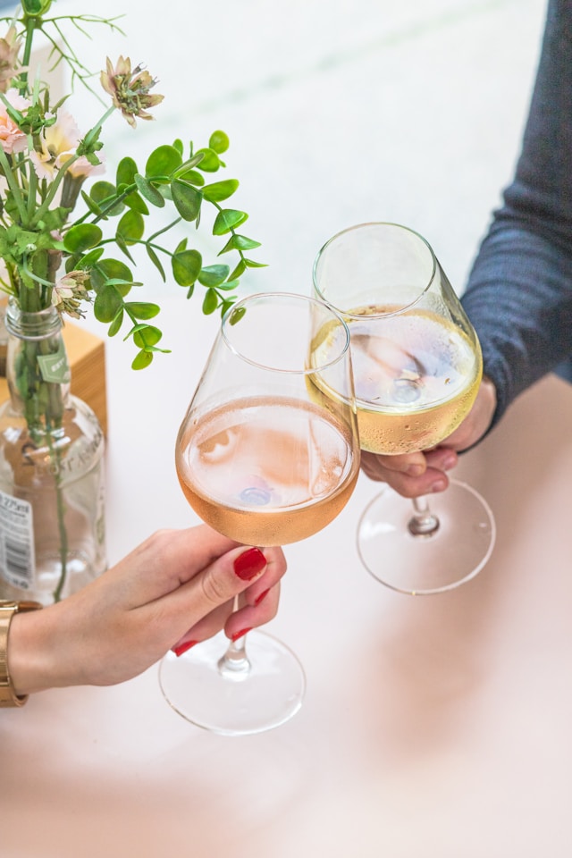 An image of two people holding glasses of wine.