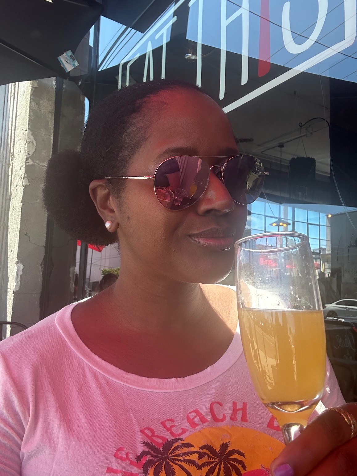 An image of lifestyle blogger Ariel at Eat This Cafe with a mimosa.