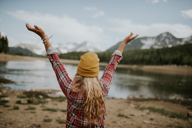 An image of a woman at a mountain lake.