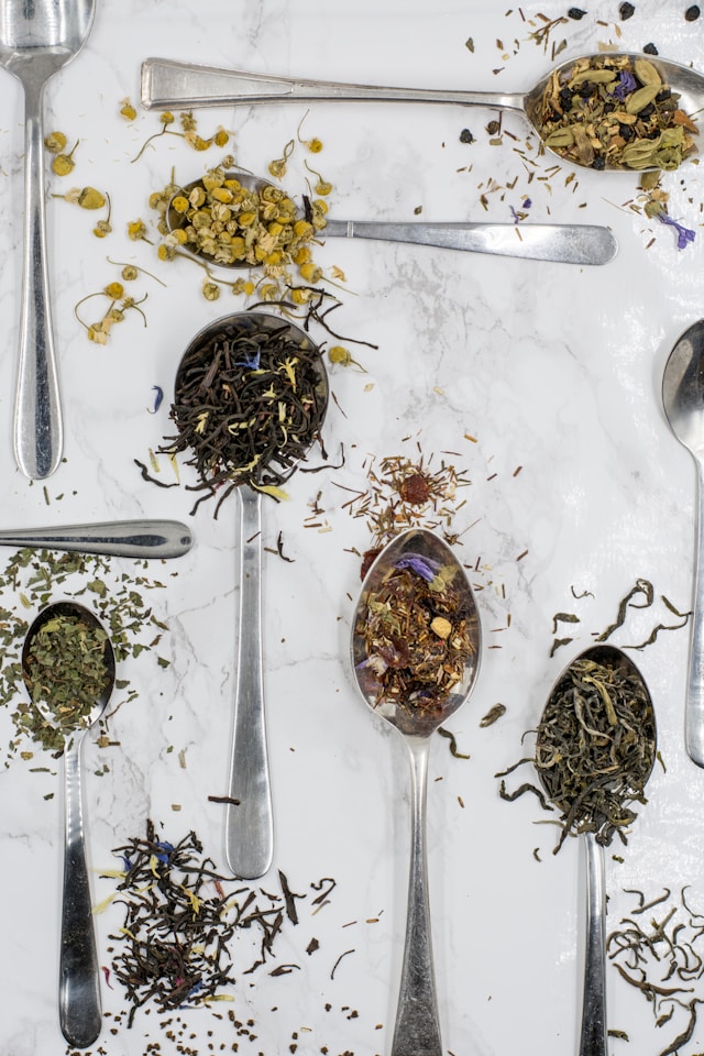 An image of loose leaf teas on spoons.