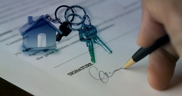 An image of someone signing a house sale contract.