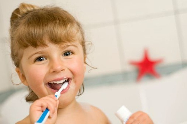 An image of a young girl brushing her teeth.