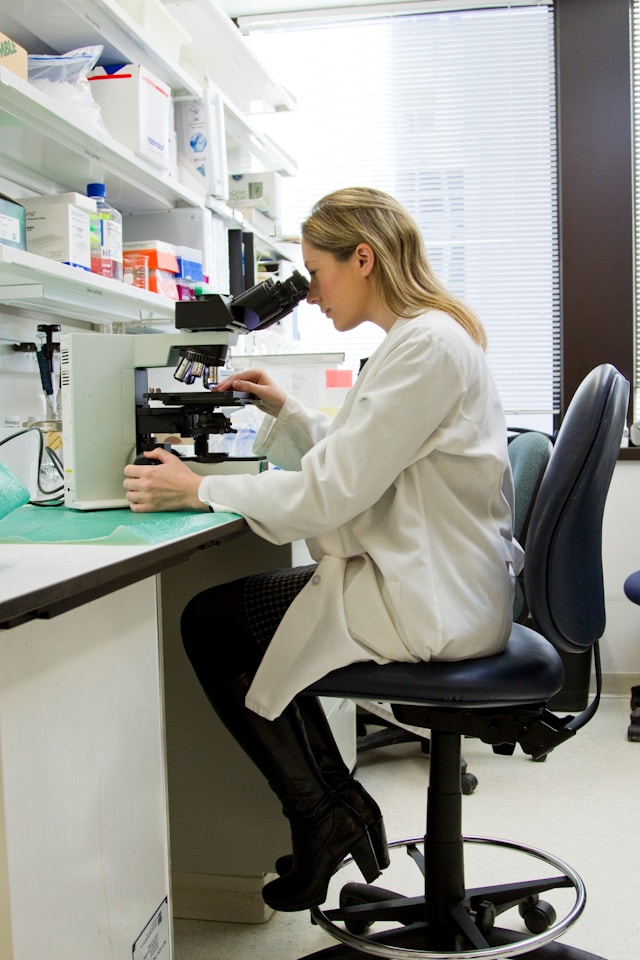 An image of a doctor using a microscope.