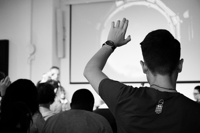 An image of a man raising his hand in class.