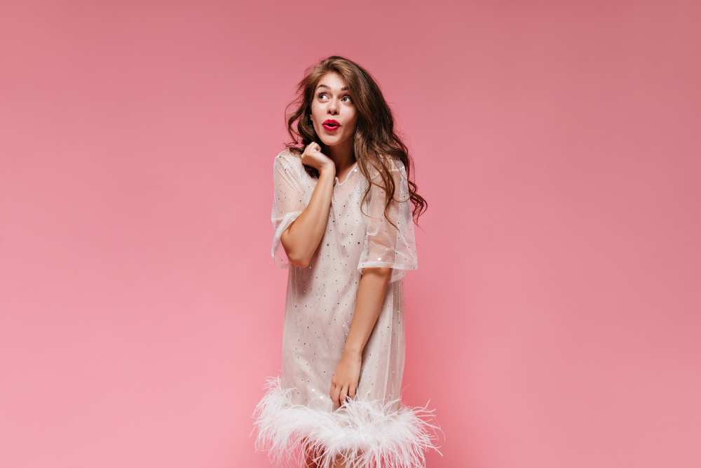 An image of a woman wearing a dress with a feather hem.