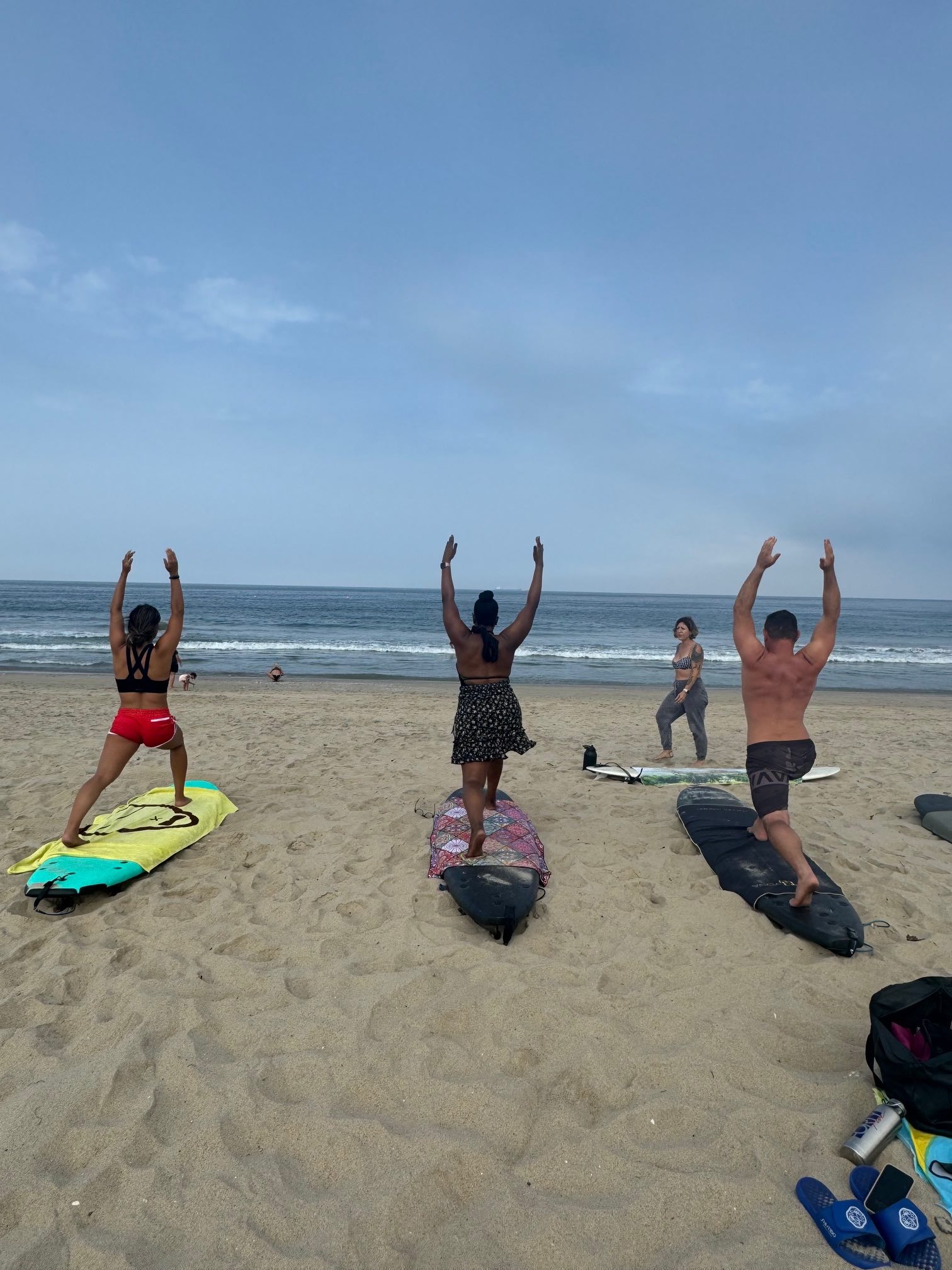 An image of lifestyle blogger Ariel with other yogis doing beach yoga at the Happy Yoga beach session.