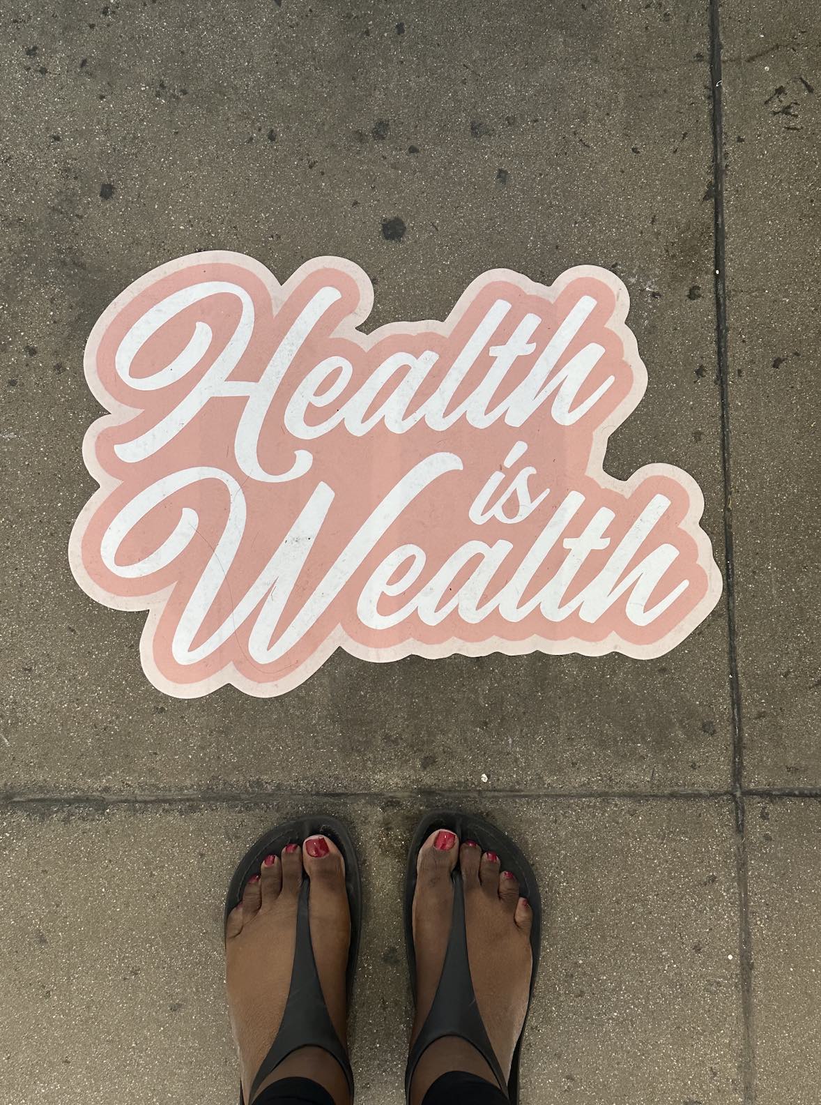 An image of a sign on the floor stating Health is Wealth.