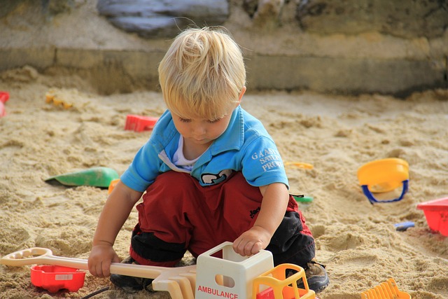 An image of a boy playing in a sandbox.