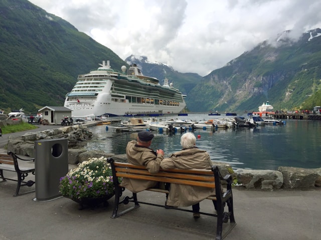 An image of two people sitting outside a cruise ship.