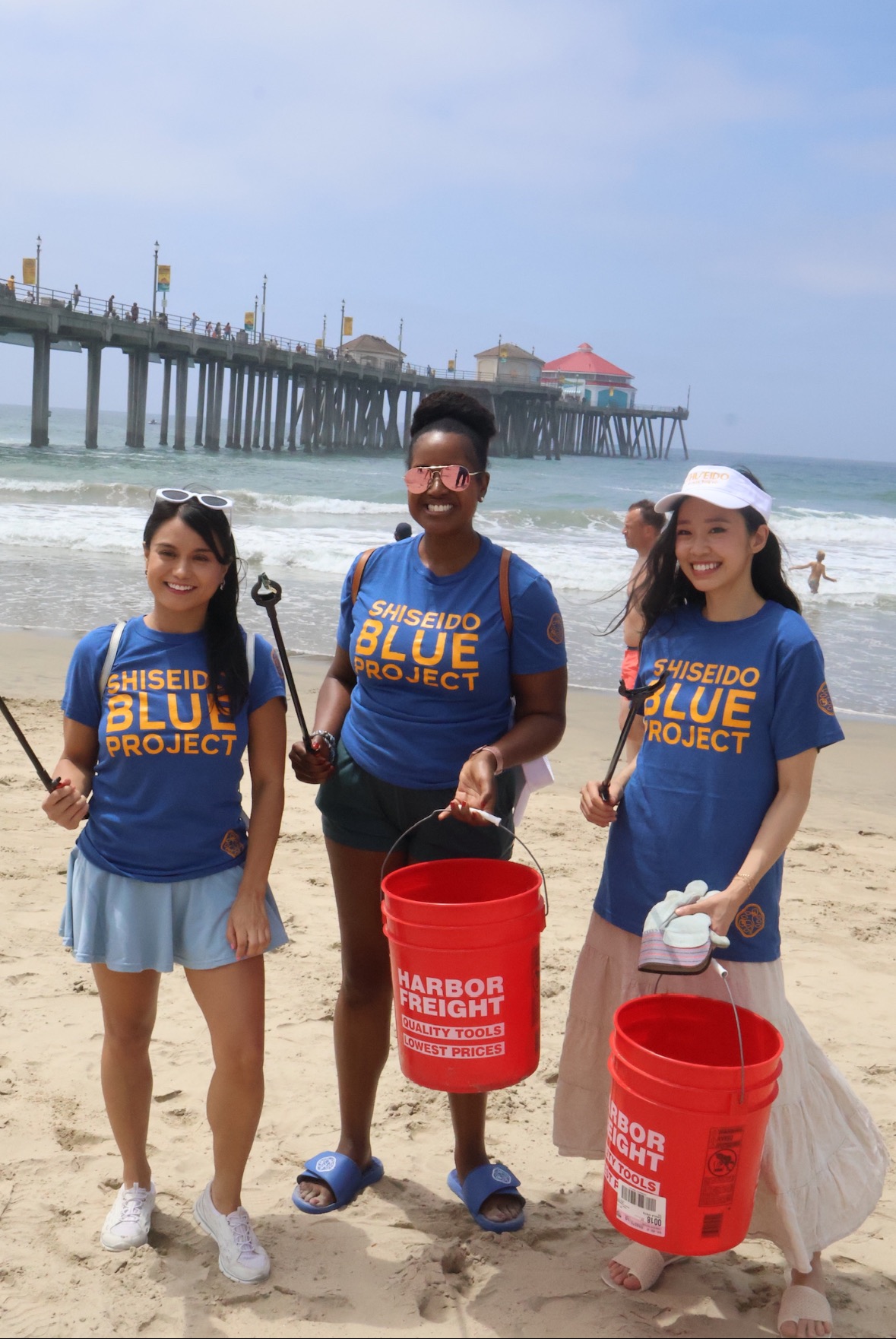 An image of three lifestyle content creators cleaning up the beach with Shiseido Blue Project.