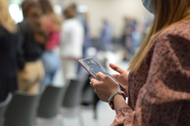 An image of a woman looking for pizza near me on her phone.