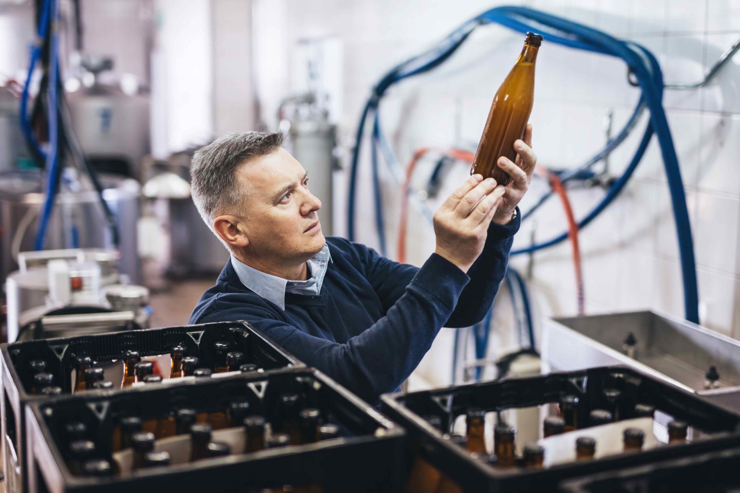 An image of a craft beer handler inspecting the craft beer.