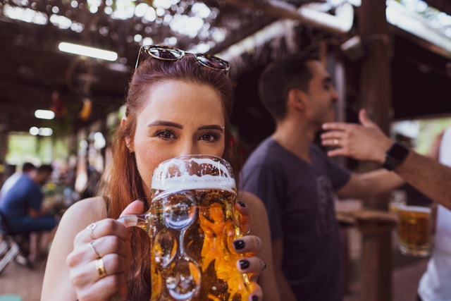 An image of a woman drinking a pint of beer at a pub.