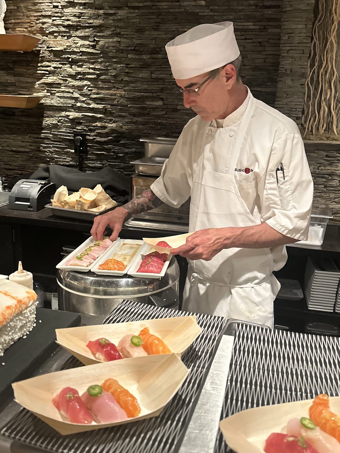 An image of a sushi chef preparing sushi at Sushi Roku.