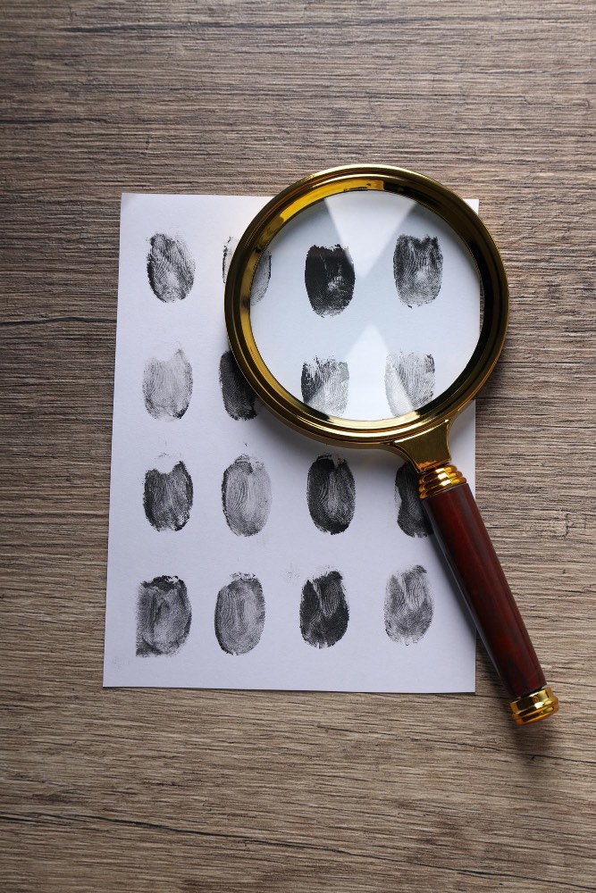 An image of fingerprints and a magnifying glass.