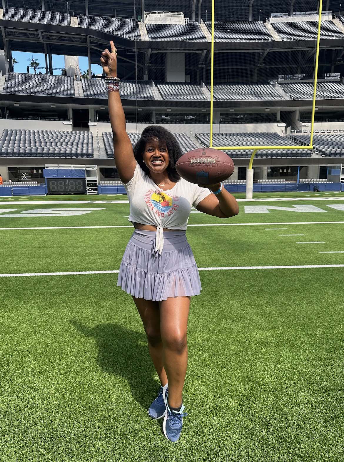 An image of lifestyle blogger Ariel on a football field holding a football.