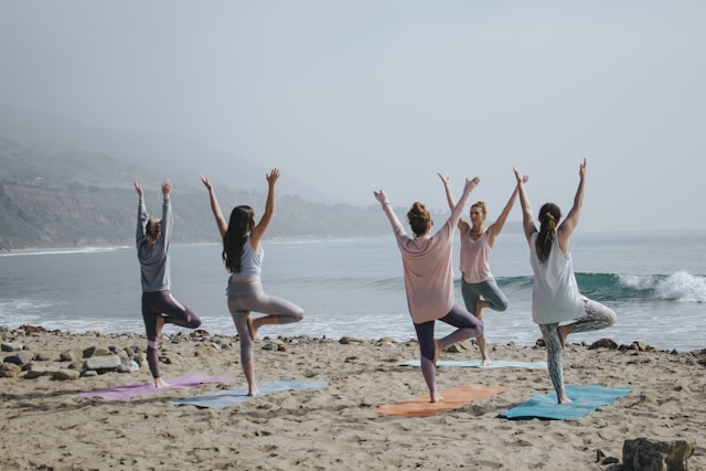 An image of people doing beach yoga.