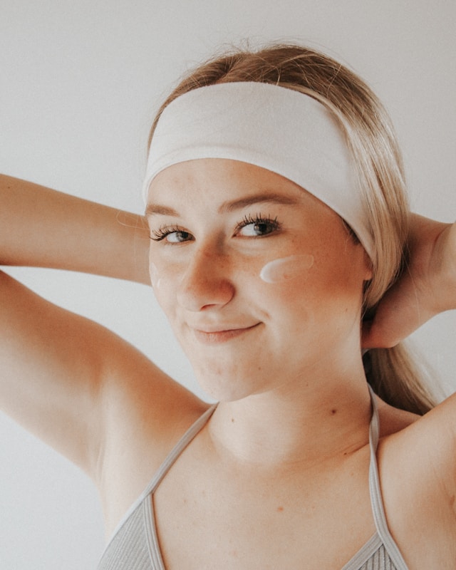 An image of a woman using a topical treatment for her biopsy scar.