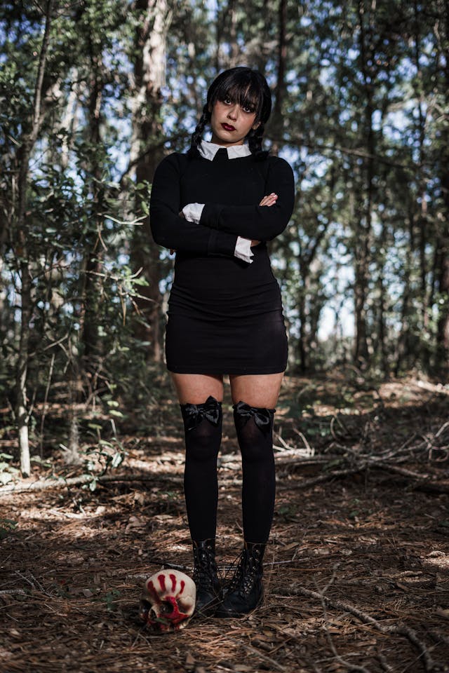 An image of a girl in a Wednesday Addams costume for a Happy Halloween..