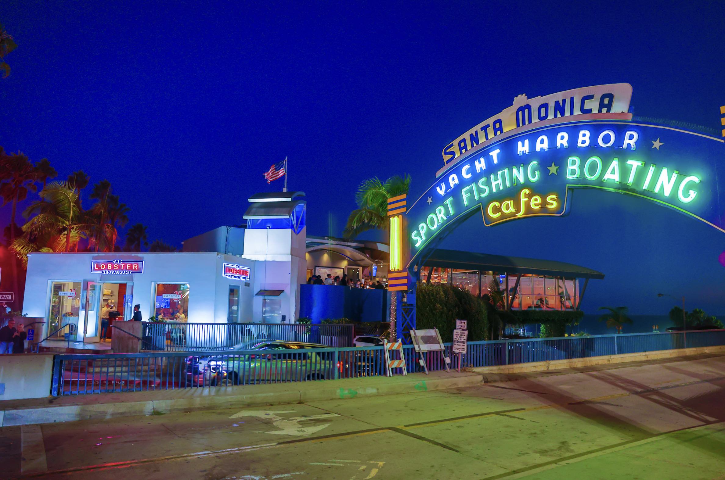 An image of the outside of The Lobster and the Santa Monica Pier sign. The Lobster serves some of the best seafood.