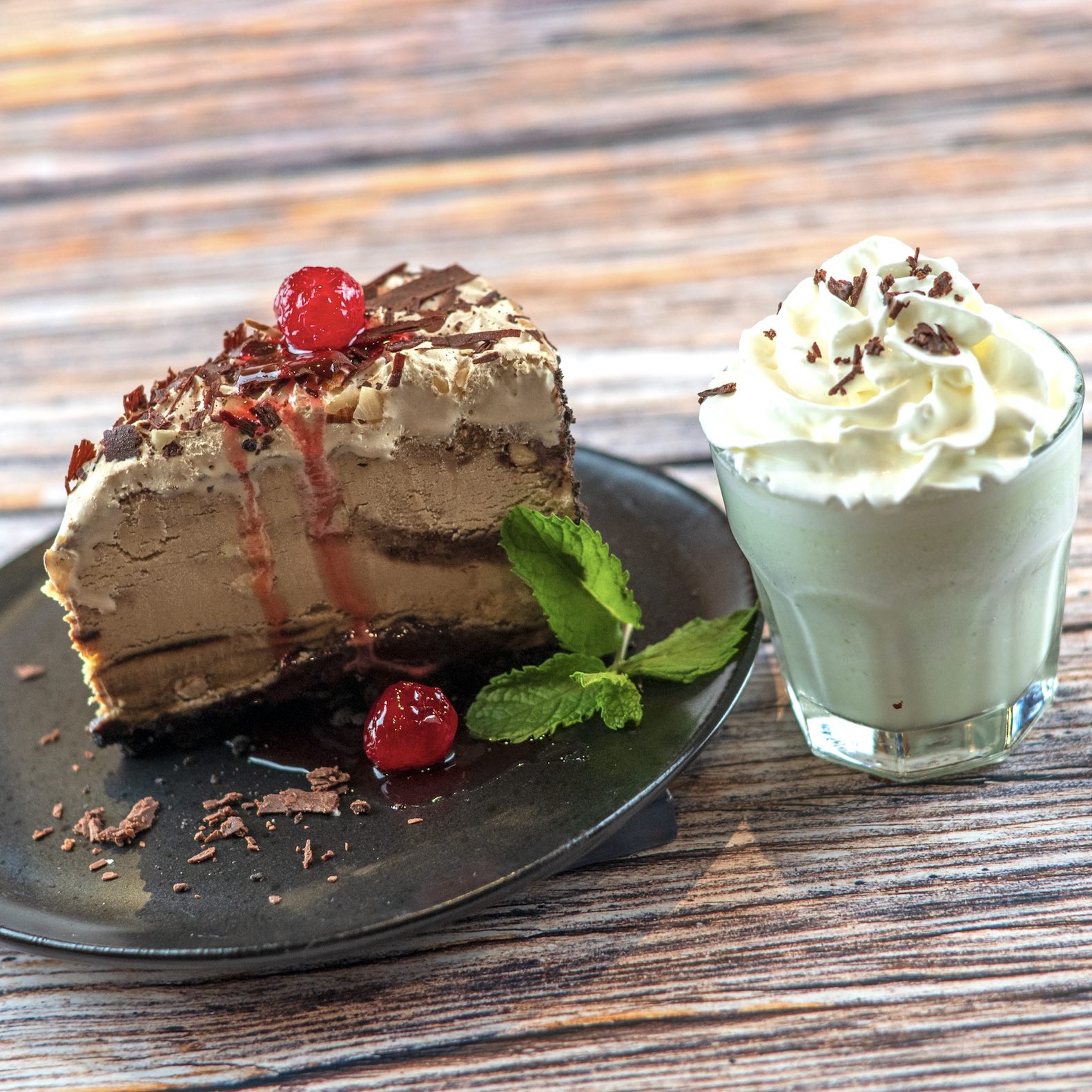 An image of Sky High Mud Pie made with Ole Smoky Moonshine-soaked cherries paired with a Mint Chocolate Chip Grasshopper cocktail at Black Angus.