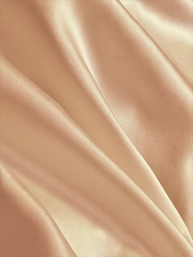 An image of champagne material representing a shawl.