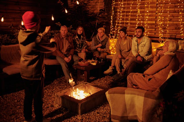 An image of a group of people sitting around a firepit