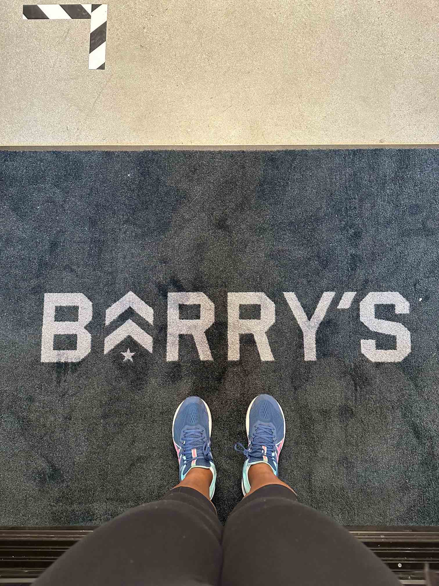 An image of lifestyle blogger Ariel standing on the Barry's floor mat.