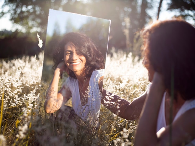 An image of a woman doing positive affirmations for women in a mirror.