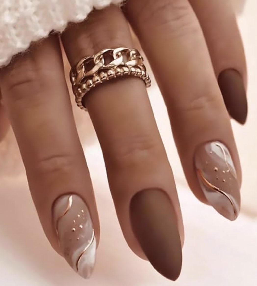 An image of a hand wearing Almond Press on Nails With Gold Line Designs.