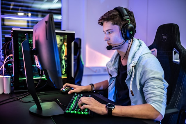 An image of a guy working at his desk while sitting in a gaming chair.