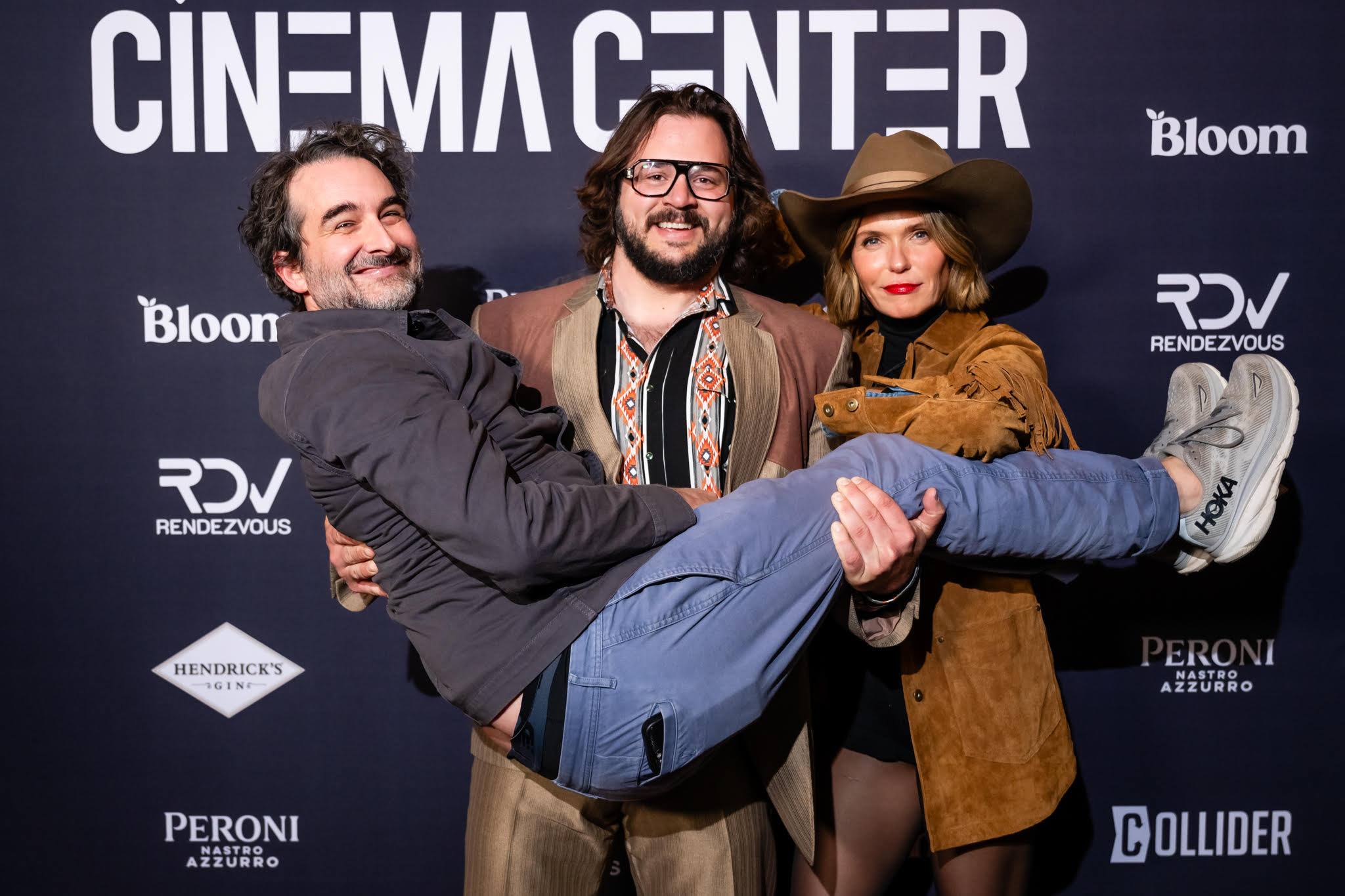 An image of Jay Duplass being held up by a man and woman.