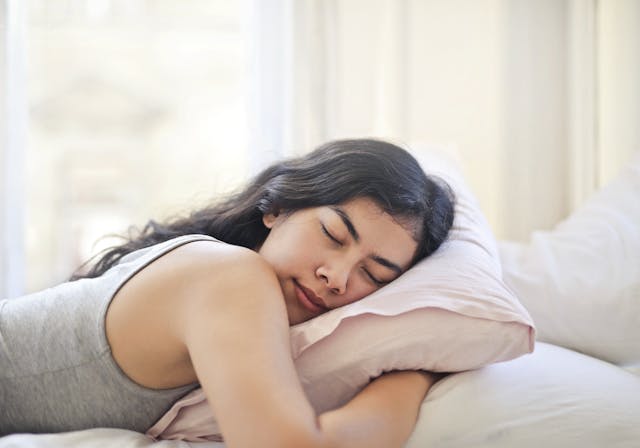 An image of a woman sleeping on a pillow.