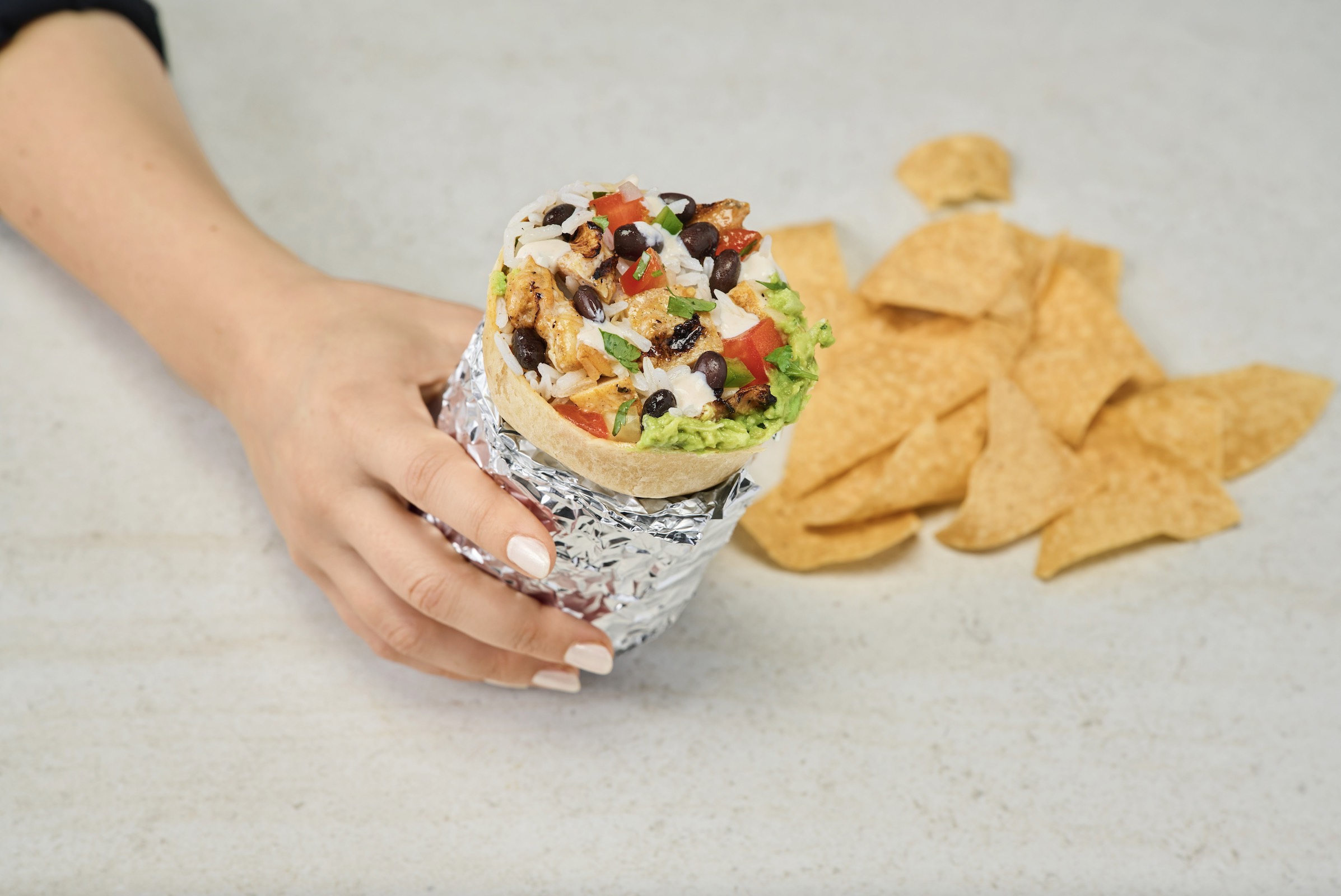 An image of a hand holding a Rubio's burrito.