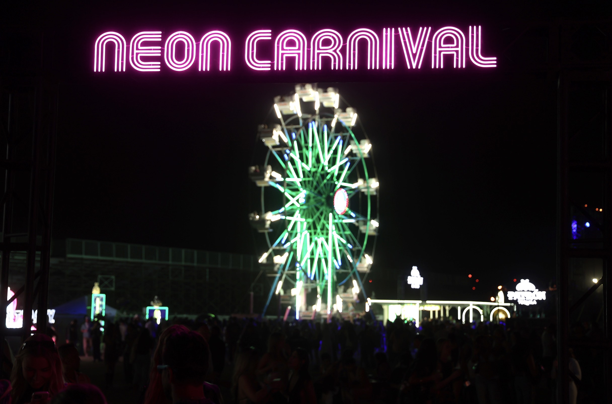An image of a neon ferris wheel and a sign reading Neon Carnival.