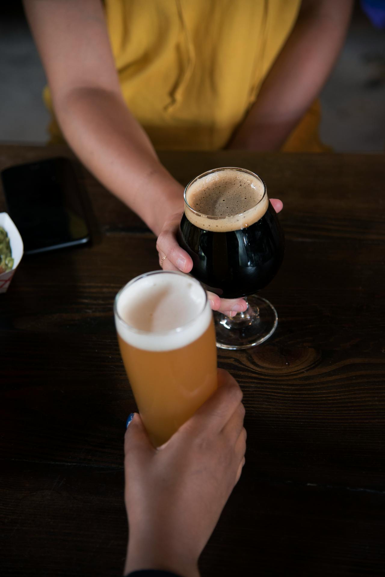 An image of two people holding glasses of beer.