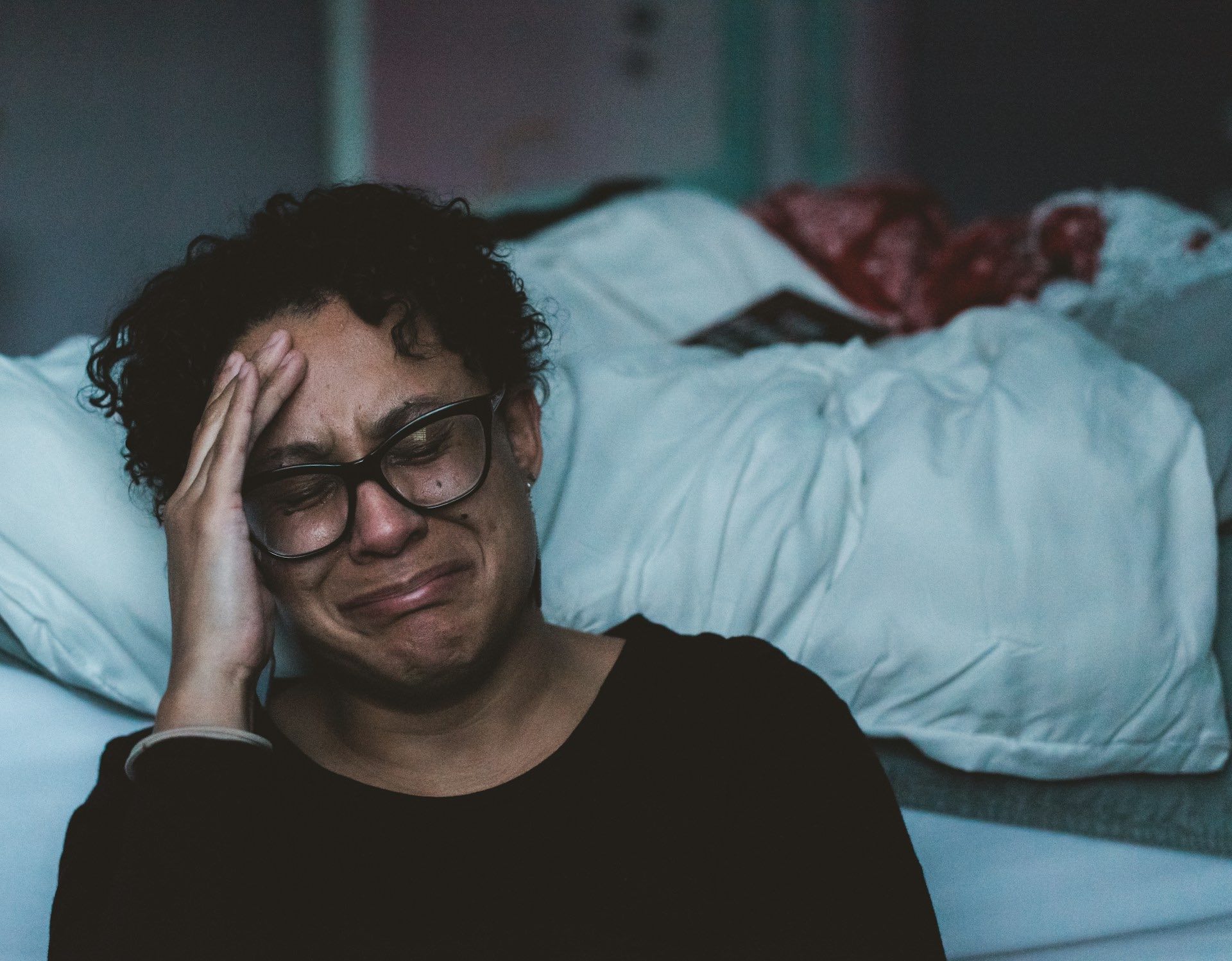An image of a woman siting on the floor crying.