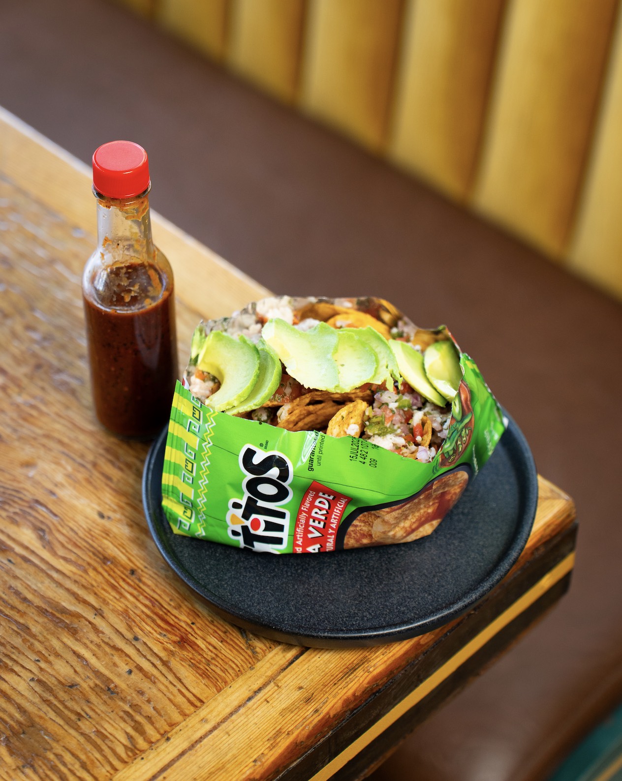 An image of Tostitos con Ceviche ($18) served in a green salsa Tostitos bag with ceviche de pescado and avocado salsa marisquera from Daisy Margarita Bar new late night menu.