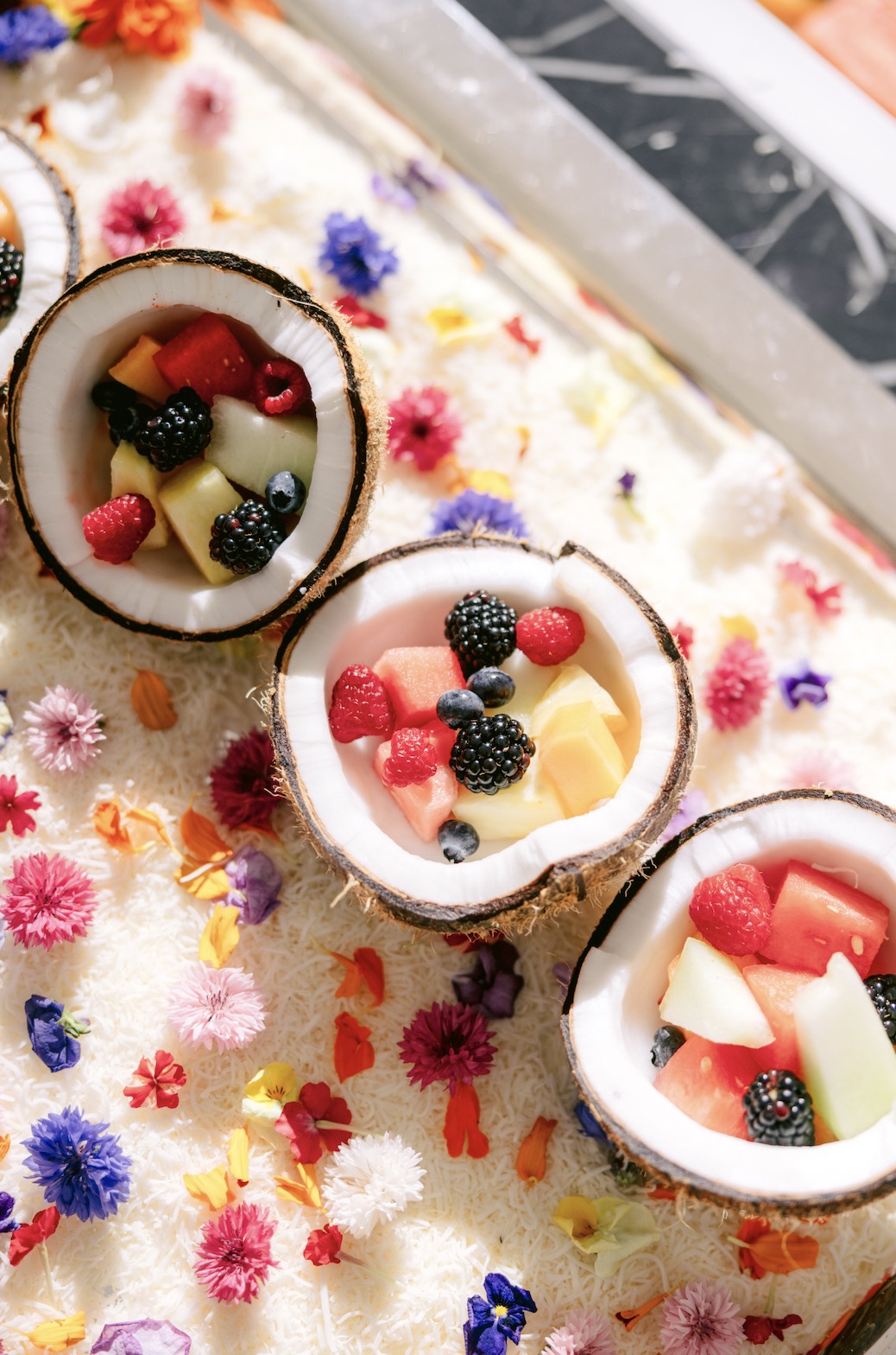 An image of 3 coconuts with fresh fruit inside.