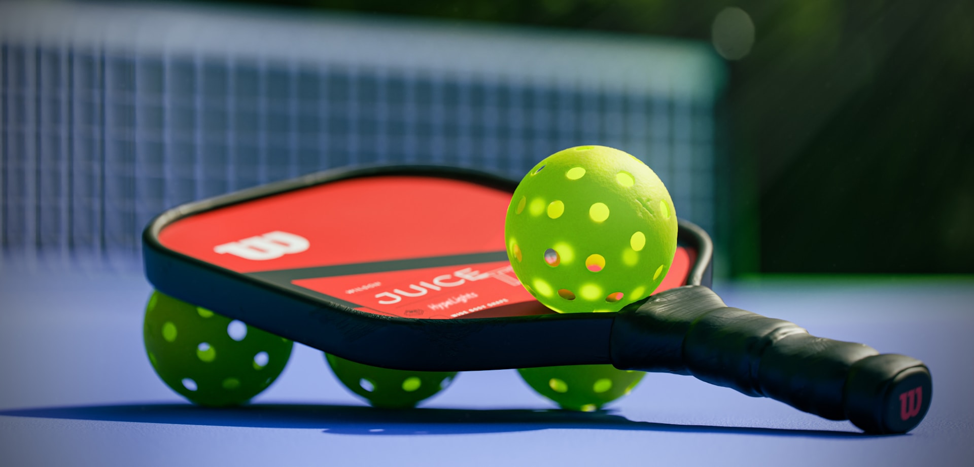 An image of a pickleball racket and 4 balls.