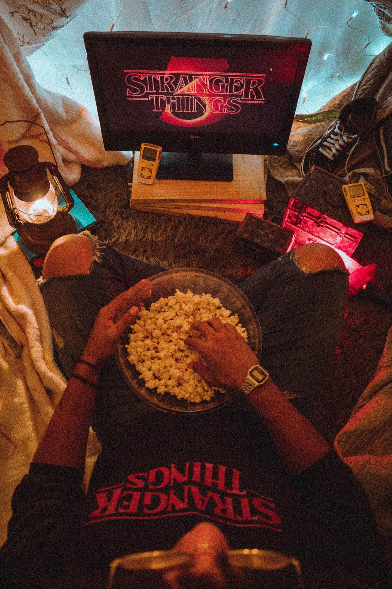 An image of someone eating popcorn watching Stranger Things.