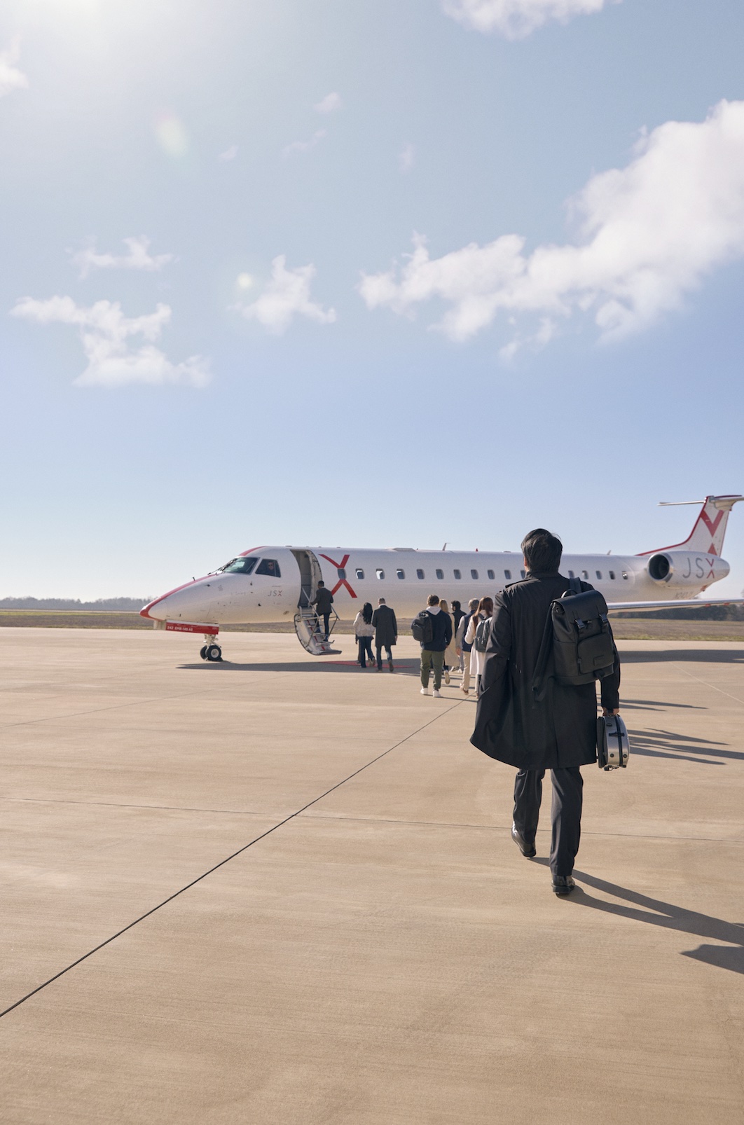 An image of people walking to board a JSX jet.