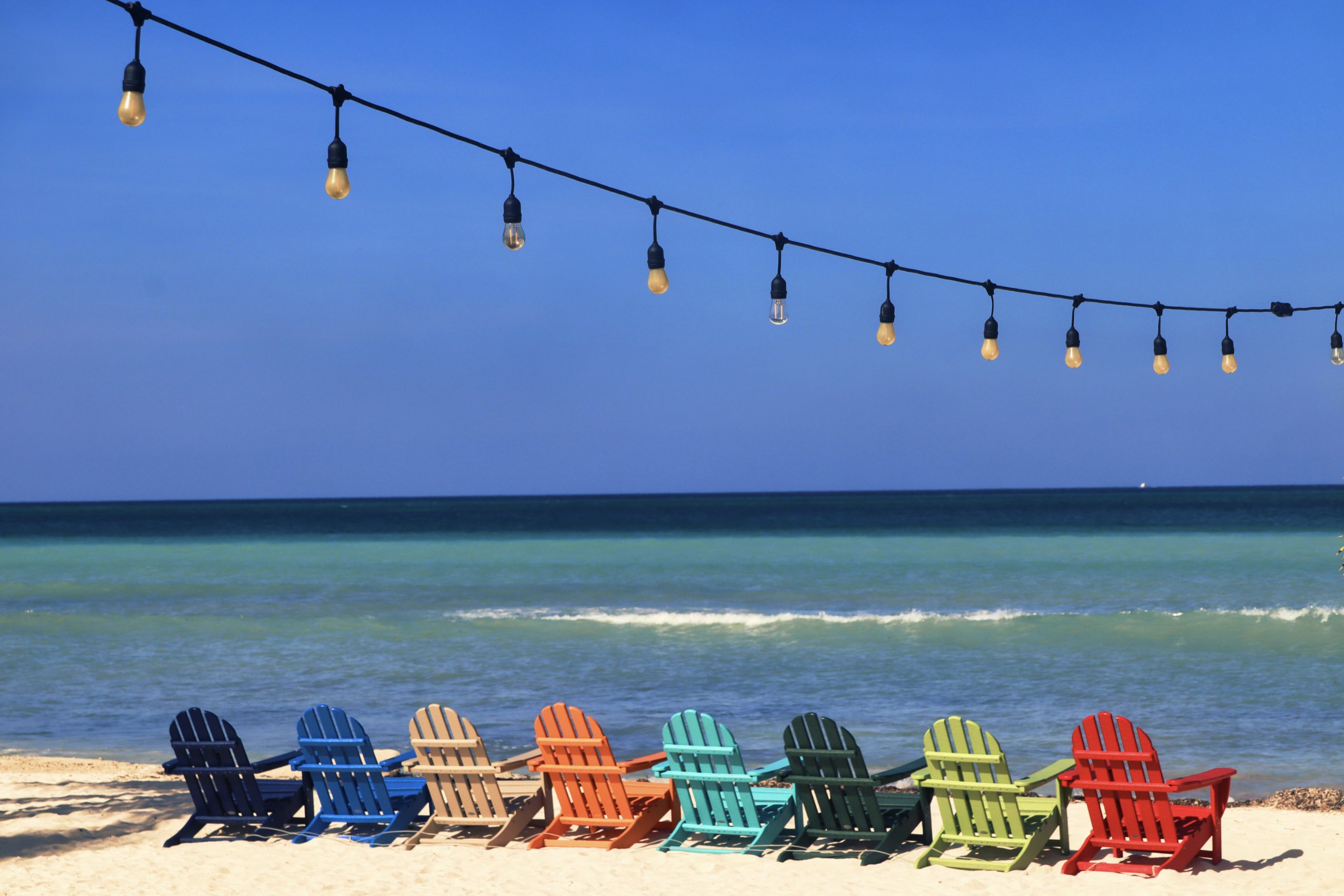 An image of colorful beach chairs on an Aruba beach.