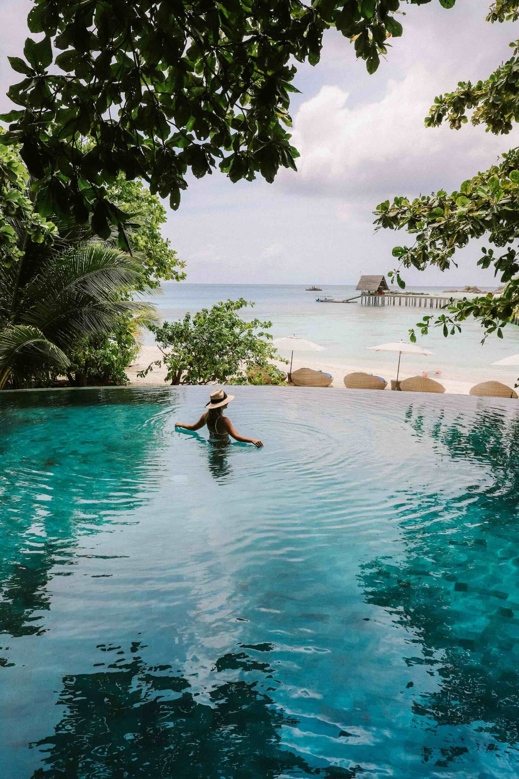 An image of a woman in a private pool on a luxury vacation.
